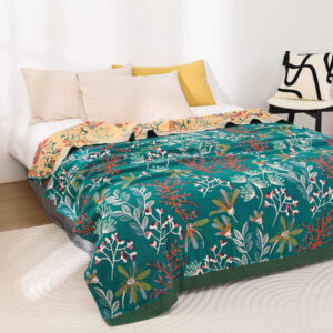 Forest green botanical throw blanket draped over a white bed