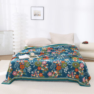 Blue Bloom throw blanket with colorful floral design on bed