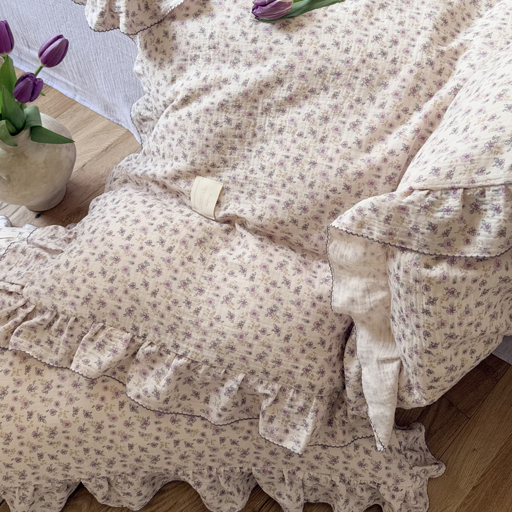 Matching ruffled pillowcases with tiny purple floral pattern