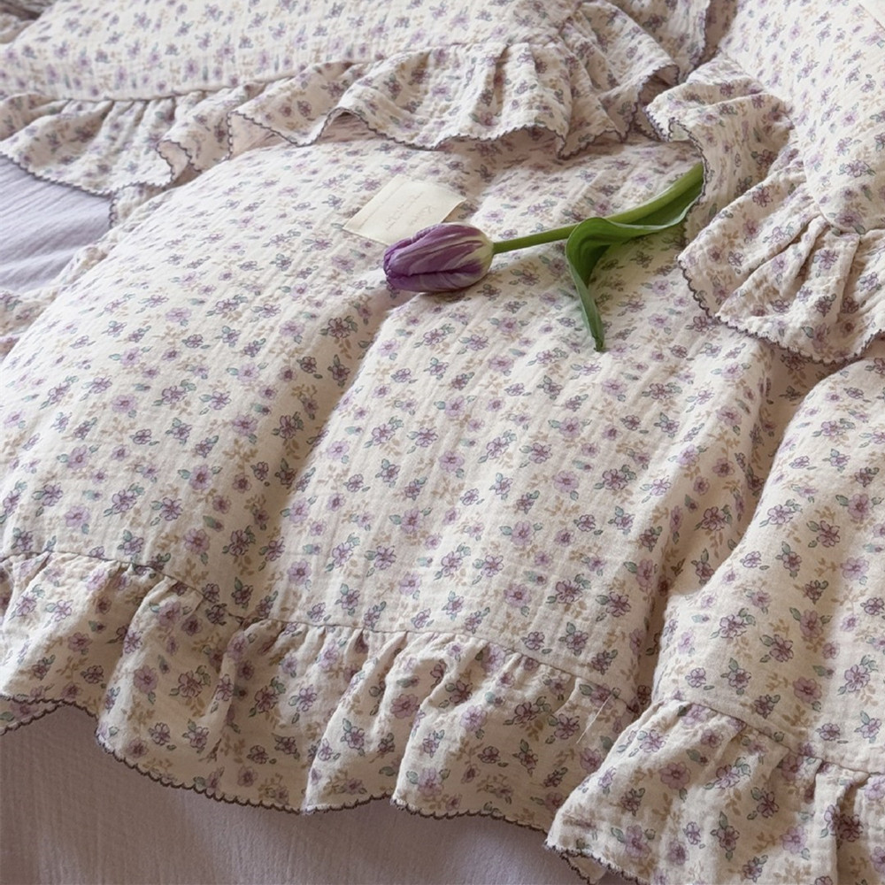 Close-up of ruffled cotton muslin duvet with purple flowers