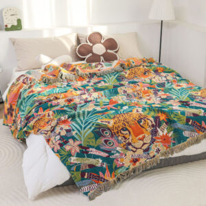 Jaguar Jungle throw blanket with fringed edges displayed on bed with colorful tropical plants